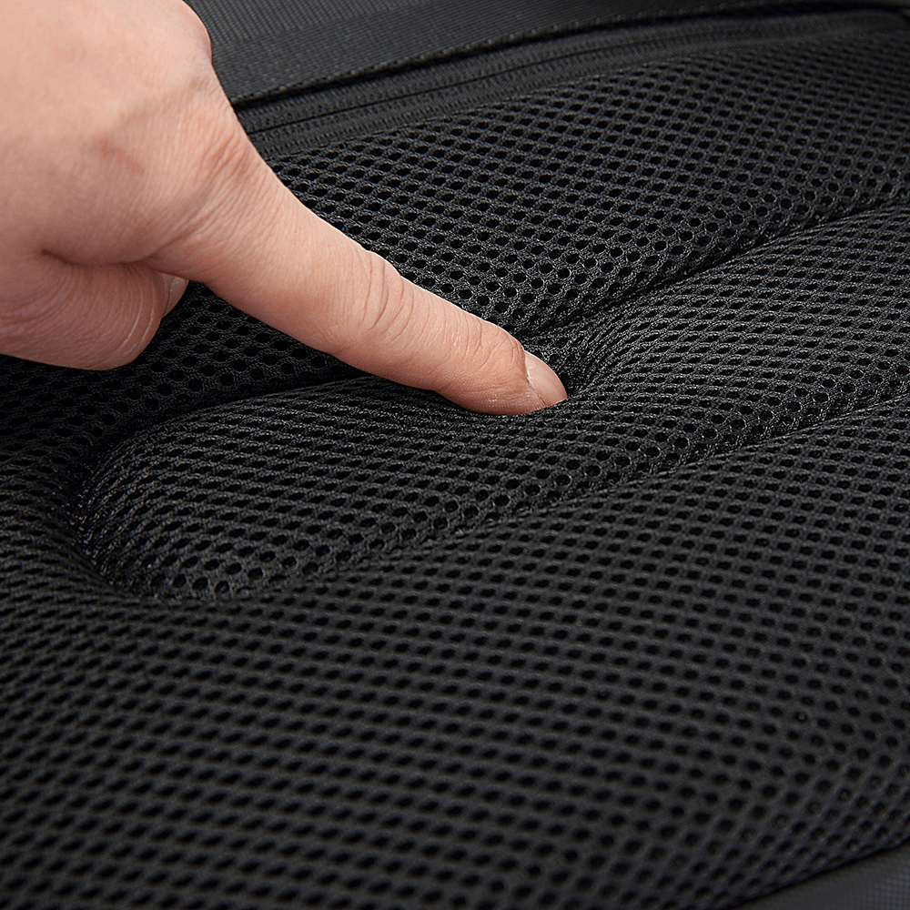 Close-up of finger pressing into breathable black mesh padding on ergonomic backpack back panel.