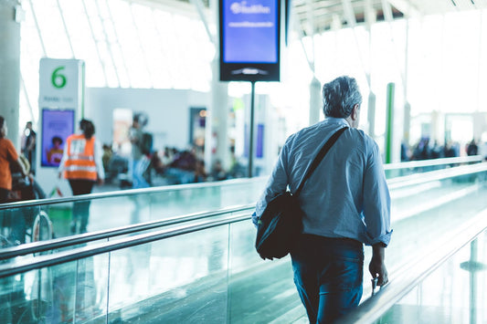 Traveler walking through an airport terminal with a single backpack